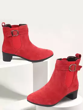 Women's suede leather ankle boots with buckle strap, red flared heel, and classic winter design.